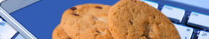 An image of cookies sitting on a mpbile phone and keyboard